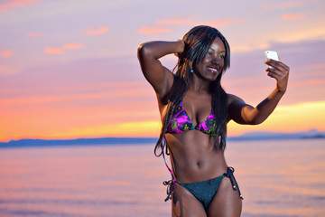 Beautiful black African American woman posing on the beach at su