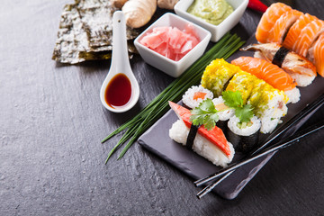 Wall Mural - Delicious sushi pieces served on black stone