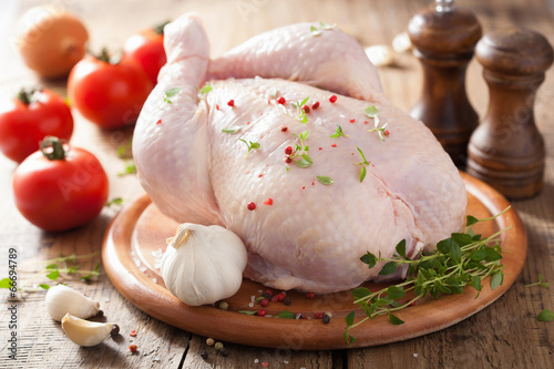 Fotografía whole raw chicken with rose pepper and thyme