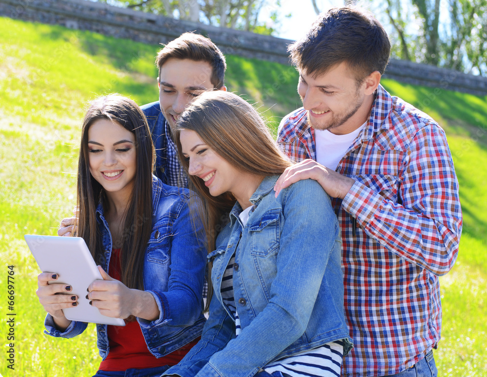 Happy students sitting in park