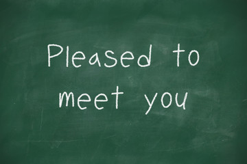 Pleased to meet you handwritten on blackboard