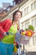 © ZoomTeam - Pretty spring  woman with bicycle and groceries in old town stre