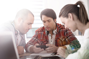 Fototapete - Group of students in school lounge using smartphone