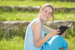 © danmorgan12 - Young Happy Caucasain Girl Reading Ebook Outdoor. Positive Facia