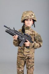 Wall Mural - Young boy dressed like a soldier with rifle