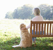 © Monkey Business - Senior woman sitting outdoors with dog