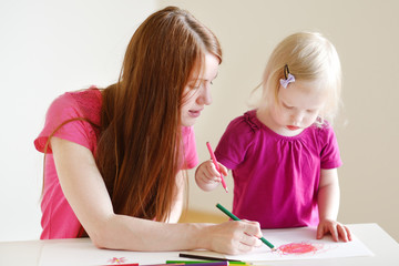 Toddler girl and her mom drawing with pencils