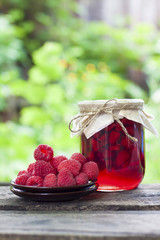 Poster - Raspberry preserve in glass jar and fresh raspberries on a plate