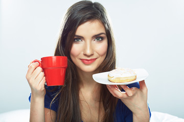 Wall Mural - Woman eating donut in bed with coffee cup.