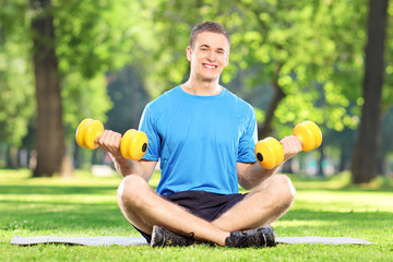 Canvas Print - Man exercising with dumbbells in a park