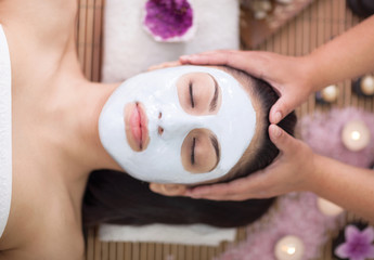   Spa therapy for young woman having facial mask at beauty salon