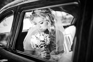 Portrait of the bride in a window of a wedding retro of the car