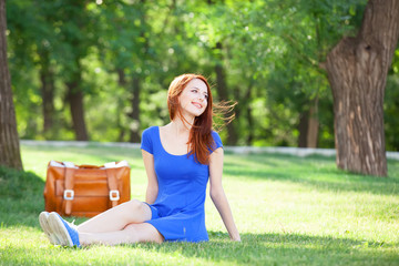 Sticker - Redhead girl with suitcase in the park.