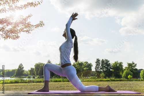 Poster Pretty woman doing yoga exercises in the park.