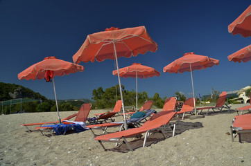 Fototapete - orange umbrellas - karavostasi beach parga greece