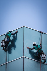 group of workers cleaning windows service on high rise building