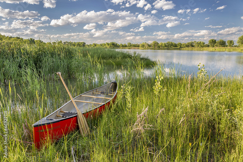 Fototapeta do kuchni red canoe on lake shore