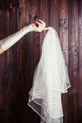 bride holding a veil against wooden background