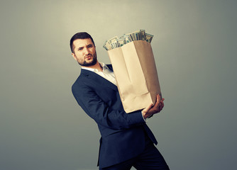 Wall Mural - businessman holding heavy paper bag