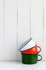 Poster - three bright colorful enameled mugs