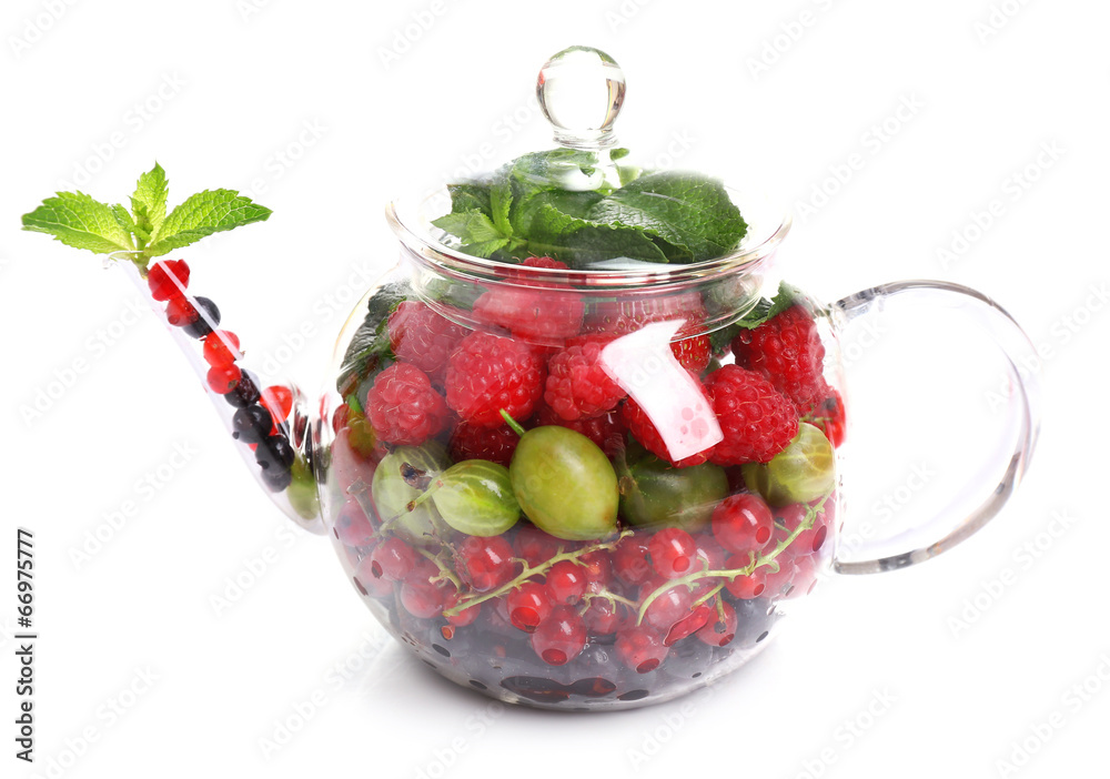 Forest berries and mint leaves in glass teapot, isolated