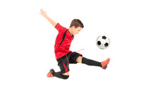 Junior Football Player Kicking A Ball