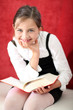 Uśmiechnięta dziewczynka czyta książkę