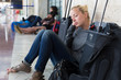 © kasto - Tired female traveler waiting for departure.