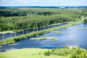 Wall Mural - Rail road aerial view with evergreen woods and blue lakes