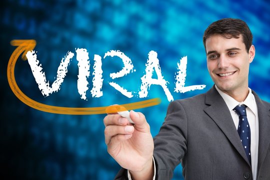 Businessman writing the word viral