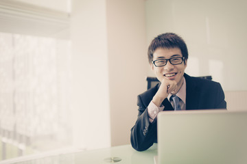 Wall Mural - Young handsome man using laptop in his office