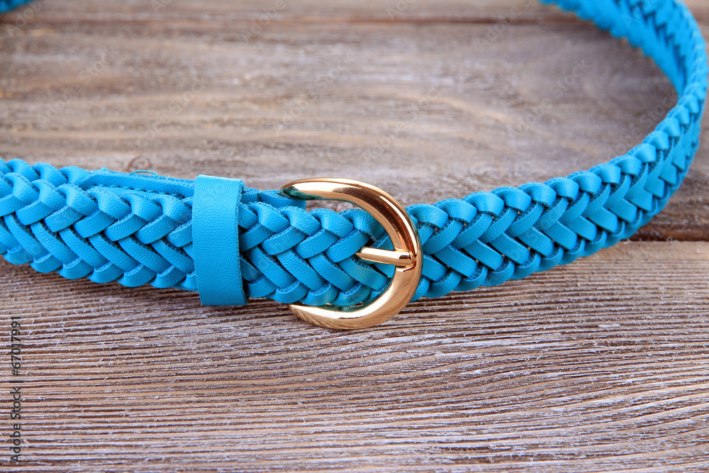 Blue leather belt on wooden background