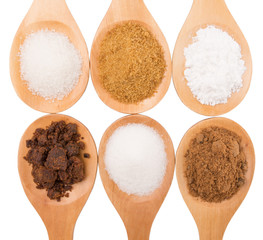 Various type of sugar on wooden spoon over white background