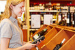 Verkäuferin erfasst Warenbestand vom Wein