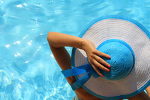 Young Lady With White Blue Hat By The Poolside