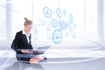 Poster - Composite image of businesswoman using laptop