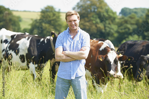 Fotografía Portrait Of Dairy Farmer In Field With Cattle