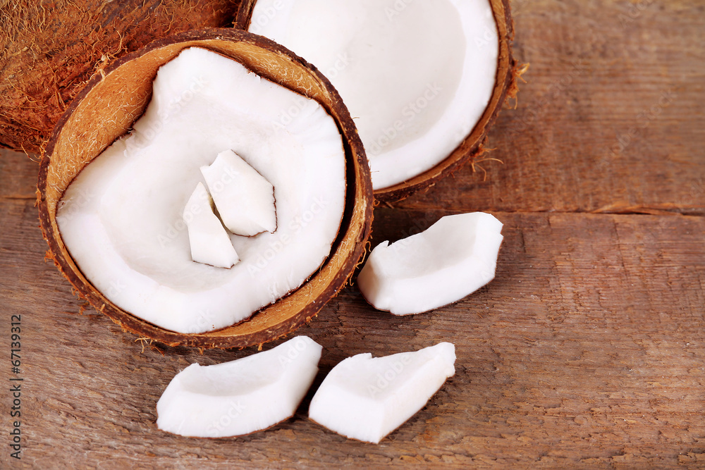 Broken coconut on wooden background