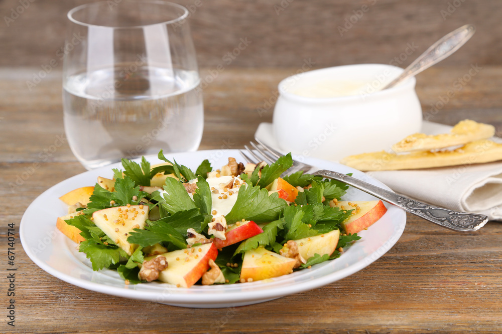 Green salad with apples, walnuts and cheese on wooden