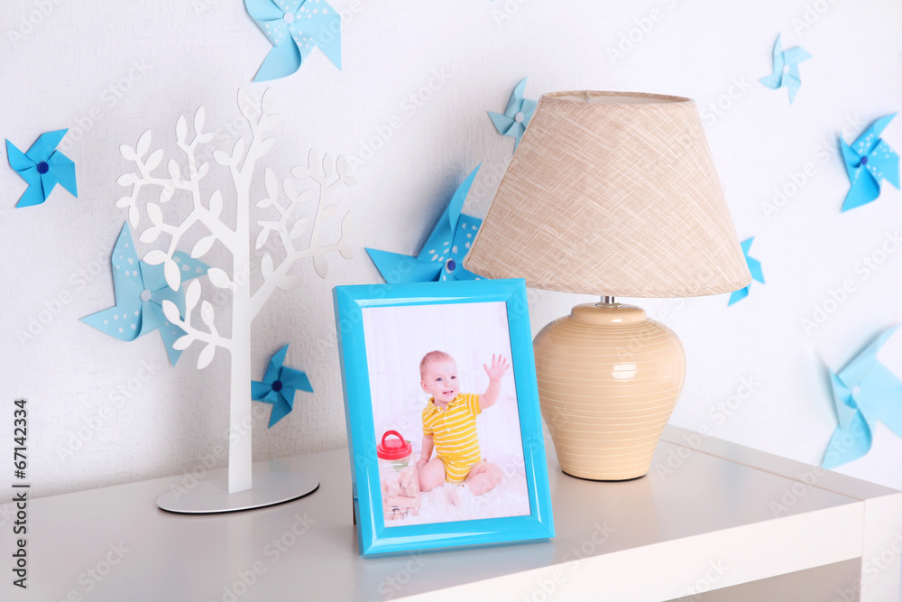 Lamp and photo frame on shelf in children room