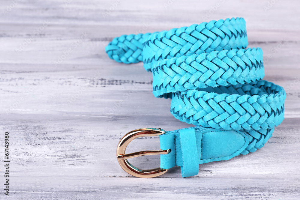 Blue leather belt on wooden background