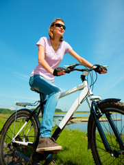 Young woman is sitting on her bicycle