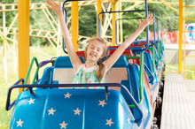 Little Girl Enjoying A Ride In A Roller Coaster