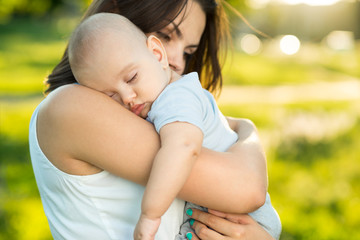 Wall Mural - Happy mother holding a young sleeping son