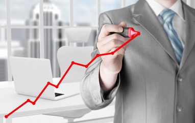 Business man drawing a growing graph