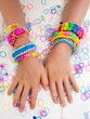 childs arms wearing multicoloured bracelets