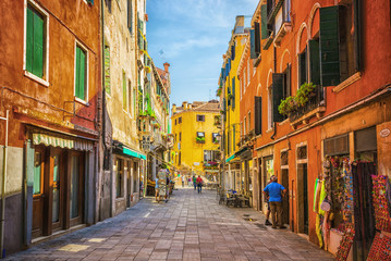 Narrow canal among old colorful brick houses in Venice