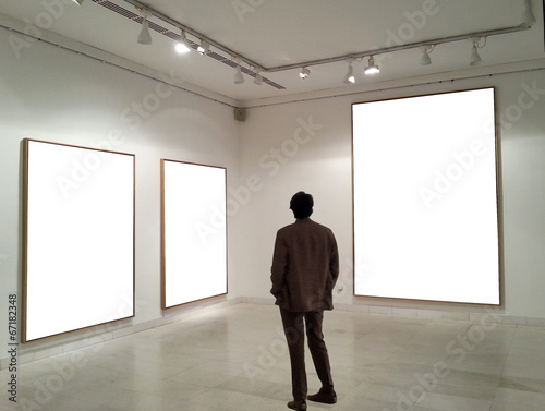 Fotografie, Obraz Man in gallery room looking at empty frames