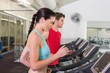 © WavebreakMediaMicro - Fit couple running together on treadmills