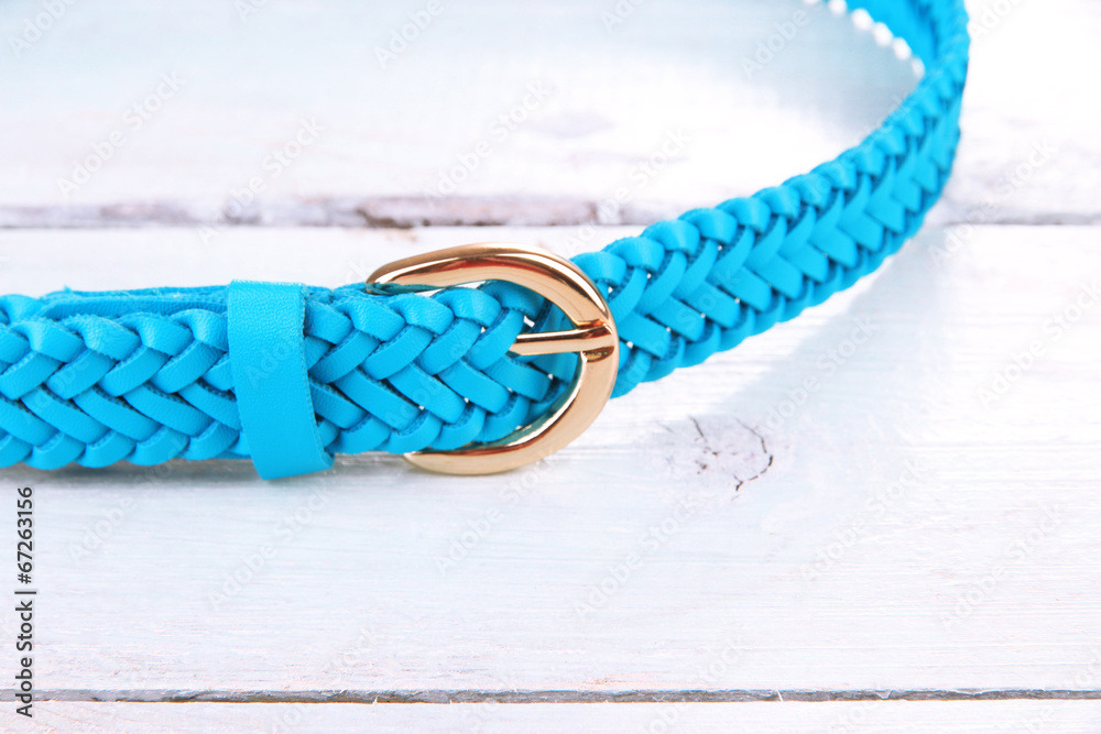 Blue leather belt on wooden background